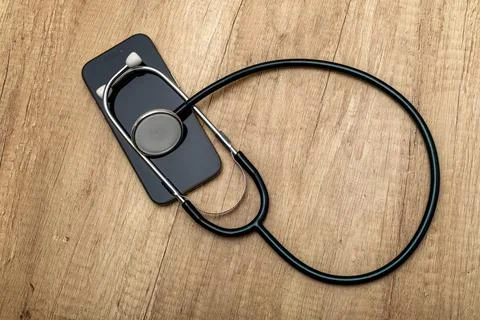 A damaged cell phone with a black screen turned off is placed on a wooden s.. Stock Photos