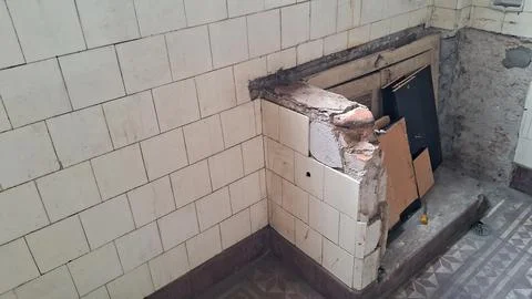 Damaged ceramic tiled kitchen wall corner during apartment renovation demolition Stock Photos