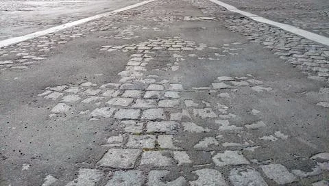 Damaged Cobblestone Road Surface With Lane Markings 스톡 사진