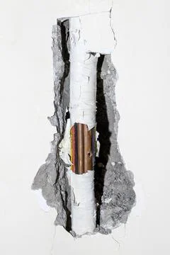 Damaged copper pipe in a wall Stock Photos