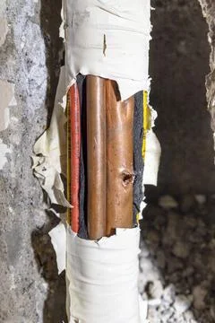 Damaged copper pipe in a wall Stock Photos