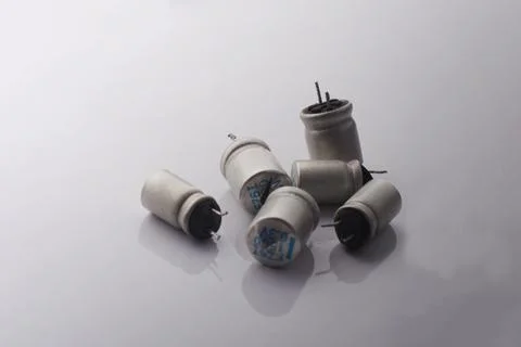 Damaged cracked electrolytic bloated exploded capacitor on white background.  Stock Photos