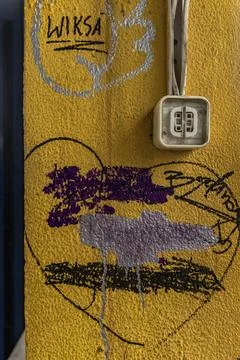 A damaged electrical socket on a dirty yellow wall, damaged electrical inst.. Stock Photos
