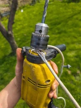 Damaged electrical wire wrapped around an old electric drill Photos