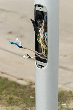 Damaged electrical wiring exposing components inside metal pole Foto stock