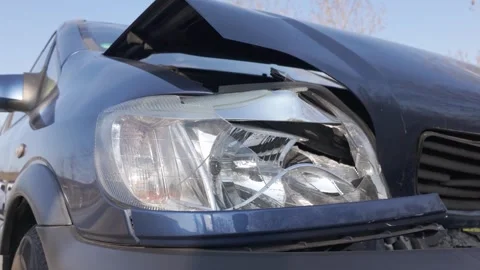 Damaged front of a dark blue car after a collision Stock Footage 344811129