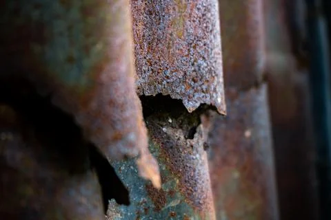 Damaged galvanized iron sheet wall on old warehouse. Detail view of old rusty Stock Photos
