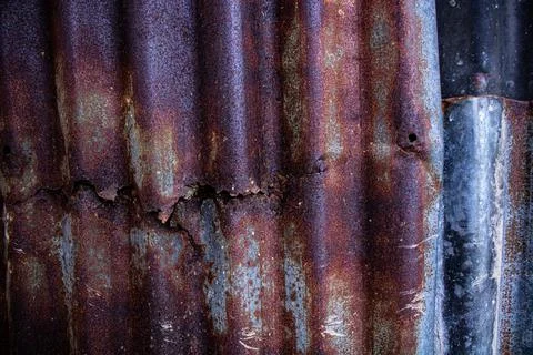 Damaged galvanized iron sheet wall on old warehouse. Detail view of old rusty Stock Photos
