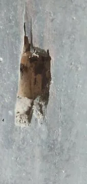 Damaged Gray Wall with Rectangular Hole Exposing Interior, Close-Up View 库存照片