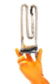 Damaged heating element of the washing machine in hand with rubber gloves. Stock Photos