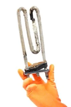 Damaged heating element of the washing machine in hand with rubber gloves. Stock Photos