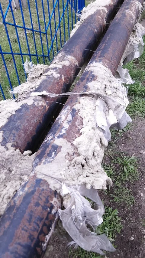 Damaged Industrial Heating Pipes with Torn Insulation on Soil Ground Stock Footage 339001714