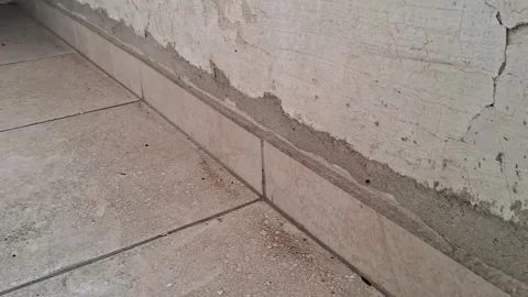 Damaged interior wall baseboard renovation video showing peeling paint plaster Stock Footage 345362133