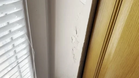 Damaged Interior Wall with Chipped Plaster Near Wooden Frame Stock Footage 345513727