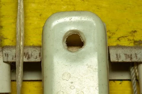 Damaged metal loop on a yellow background with ropes and rigging details Stockfoto's
