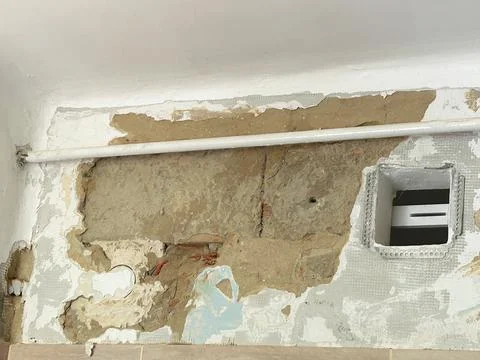 Damaged Old Interior Wall,  Peeling Paint and Exposed Plaster During Renovation Stock Photos