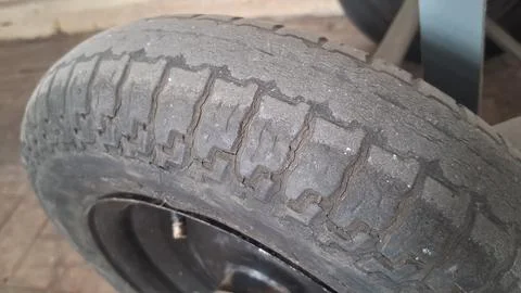 Damaged old rubber tire with deep cracks showing severe weathering Stock Photos