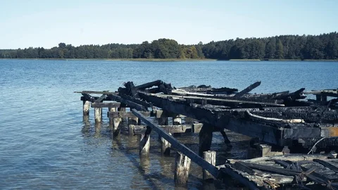 Damaged old rustic pier – bridge by fire on the lake Stock-Footage 94105278