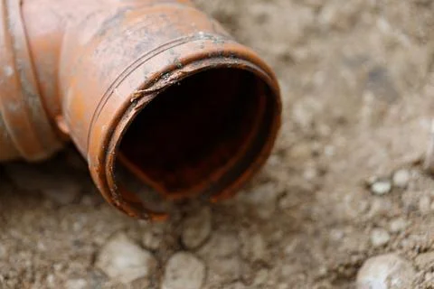 Damaged Orange Pipe on Soil Stock Photos