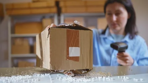 A damaged parcel,a broken female box is checked by a warehouse worker with a Vídeo Stock 270709564