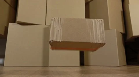 Damaged parcel falling down on the floor. Brown cartons background. Flaw and Stock Footage 67677586