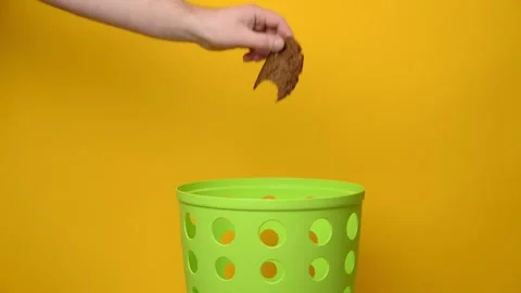 A damaged piece of bread is thrown into a garbage bucket. Stock Footage 194566393