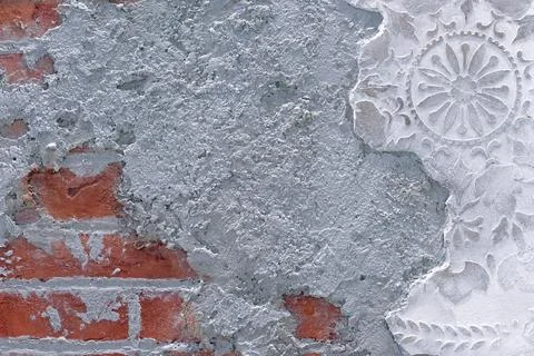 Damaged plaster on brick wall background. Brickwork under crumbling. Foto stock