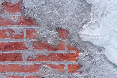 Damaged plaster on brick wall background. Brickwork under crumbling texture. Foto stock