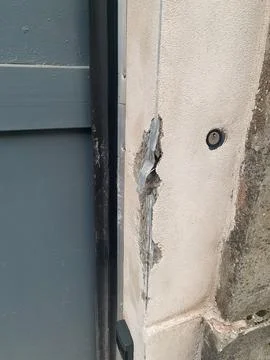 Damaged rendering and exposed insulation on an old concrete wall next to a .. Stock Photos
