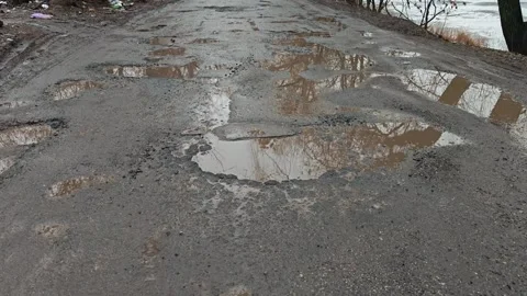 Damaged road with puddles and deep potholes Stock Footage 340030408