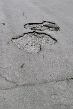 Damaged road surface with deep pothole. Ruined street in urgent need of repair Foto stock