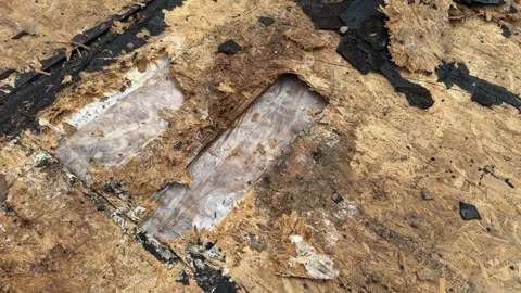 Damaged roof surface with exposed insulation and deteriorated roofing materials Stock Footage 346757192