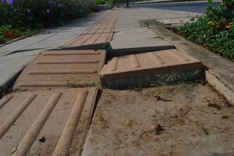 Damaged sidewalks are caused by collapsed soil. Stock Photos