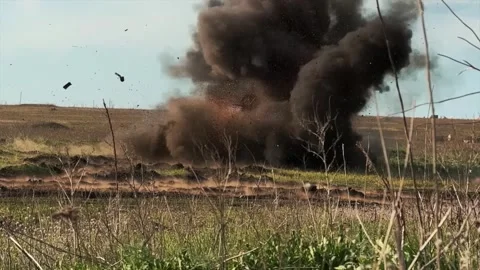 Damaged tank exploding and burning on a green field Stock Footage 313255426