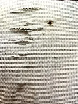 Damaged textured fabric background showing worn-out threads and a small hole Stock-Fotos