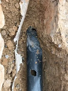 Damaged water pipe leaking in underground trench 写真素材