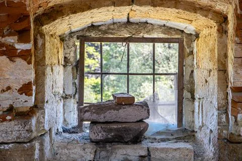 A damaged window with bars in an abandoned building Foto stock
