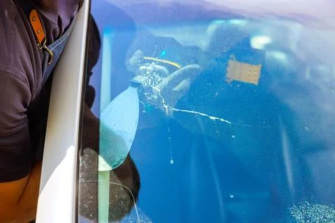 Damaged windshield with crack spreading across glass. Car window showing impact Foto stock