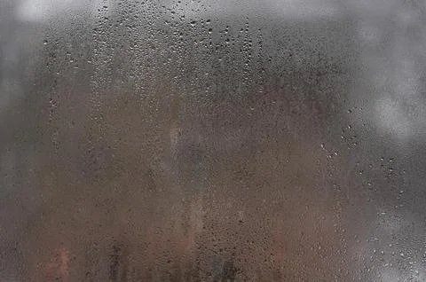 Damp window surface displays thick condensation from indoor temperature contrast Stock Photos