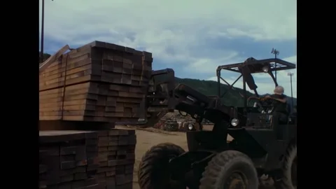 DANANG - 1966 - A large stack of lumber sits on a truck. A forklift moves in, Stock Footage 312790238