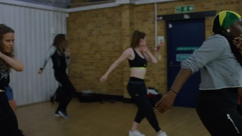 Dance class teacher leading a diverse class in a dance step routine Stock Footage 118939202