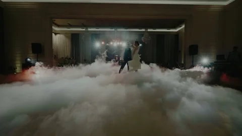Dance of a couple in the spotlights and surrounded by fog and creeping smoke Video stock 131144974