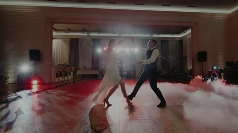 Dance of a couple in the spotlights and surrounded by fog and creeping smoke Video stock 131153548