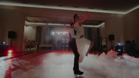 Dance of a couple in the spotlights and surrounded by fog and creeping smoke Stock Footage 131153626