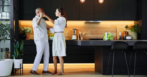 Dance, funny and love with interracial couple in kitchen of home together for Vidéo 301367346