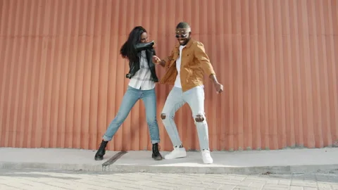 Dance loop of artistic young people couple dancing outdoors having fun on wall Stock Footage 161393987