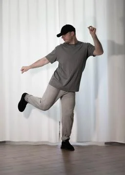 Dance in motion, pose of a man in hip-hop style clothes. Sports dancing guy.. Stock Photos
