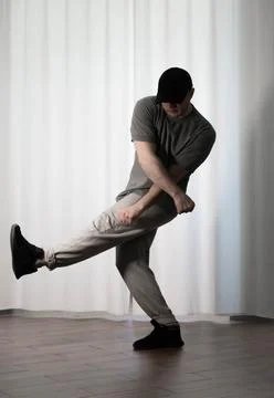 Dance in motion, pose of a man in hip-hop style clothes. Sports dancing guy.. Stock Photos