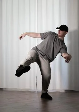 Dance in motion, pose of a man in hip-hop style clothes. Sports dancing guy.. Stock Photos