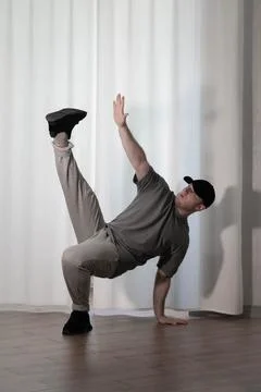 Dance in motion, pose of a man in hip-hop style clothes. Sports dancing guy.. Stock Photos